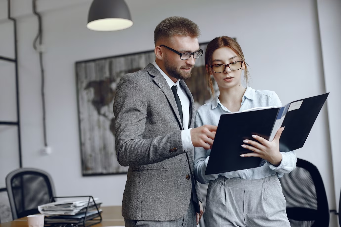 mujer-gafas-hombre-negocios-documentos-colegas-trabajan-juntos_1157-40435
